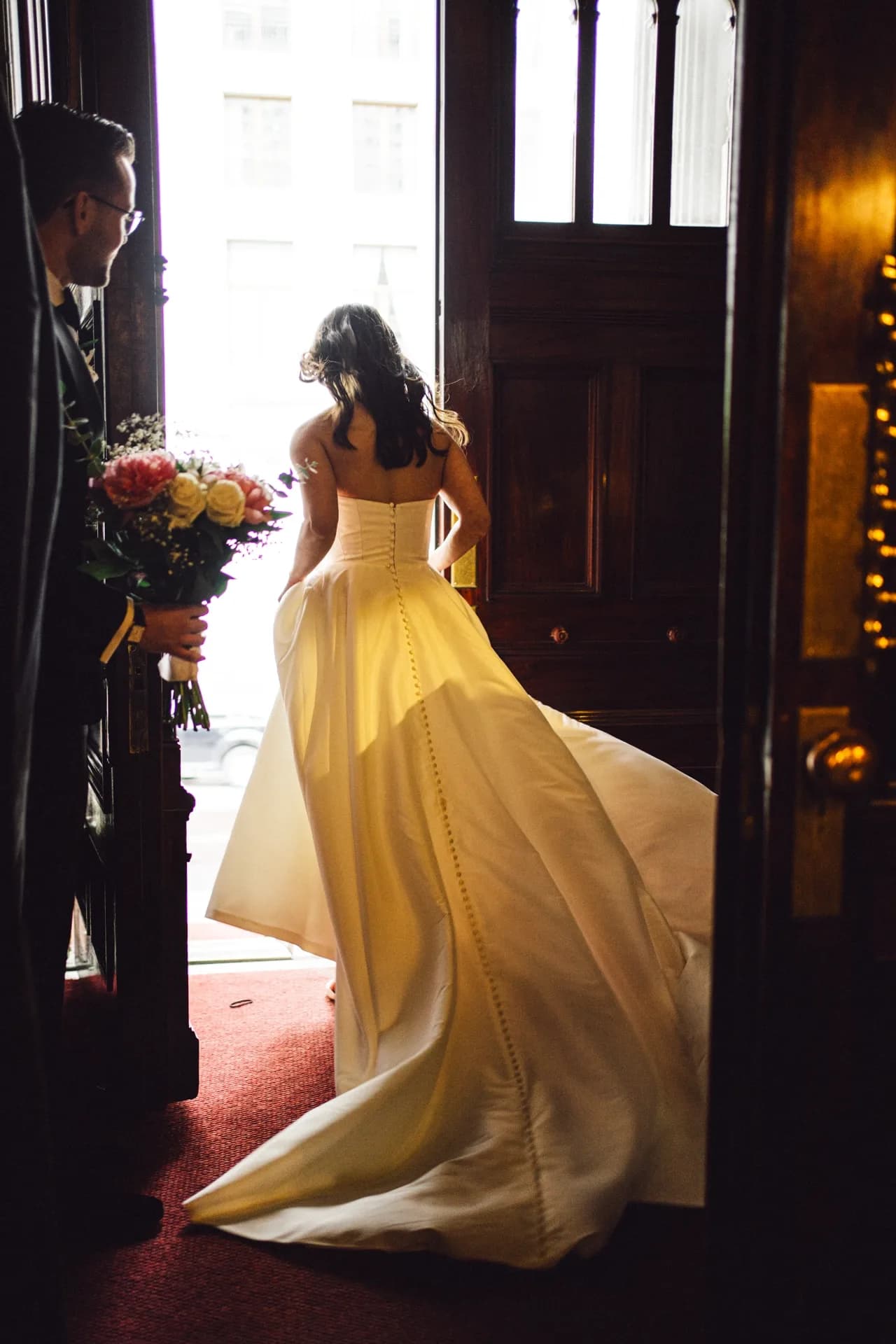 La mariée descendant un escalier, bouquet à la main